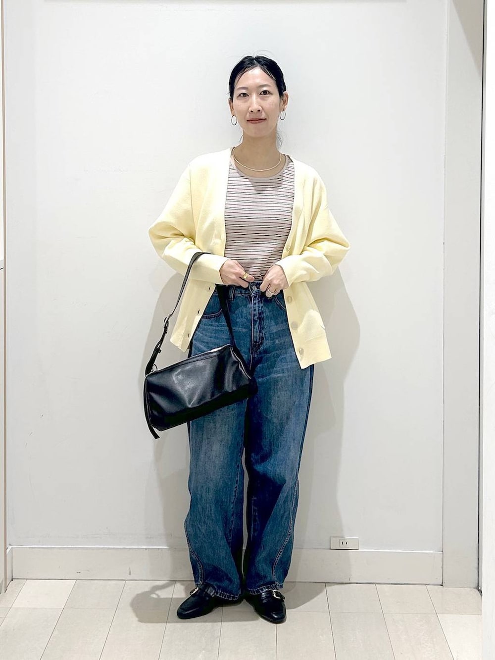 ブラック系のローファー、ブルー系のデニムパンツ、イエロー系のカーディガン/ボレロを着用したレディースの春コーディネートの5枚目の写真