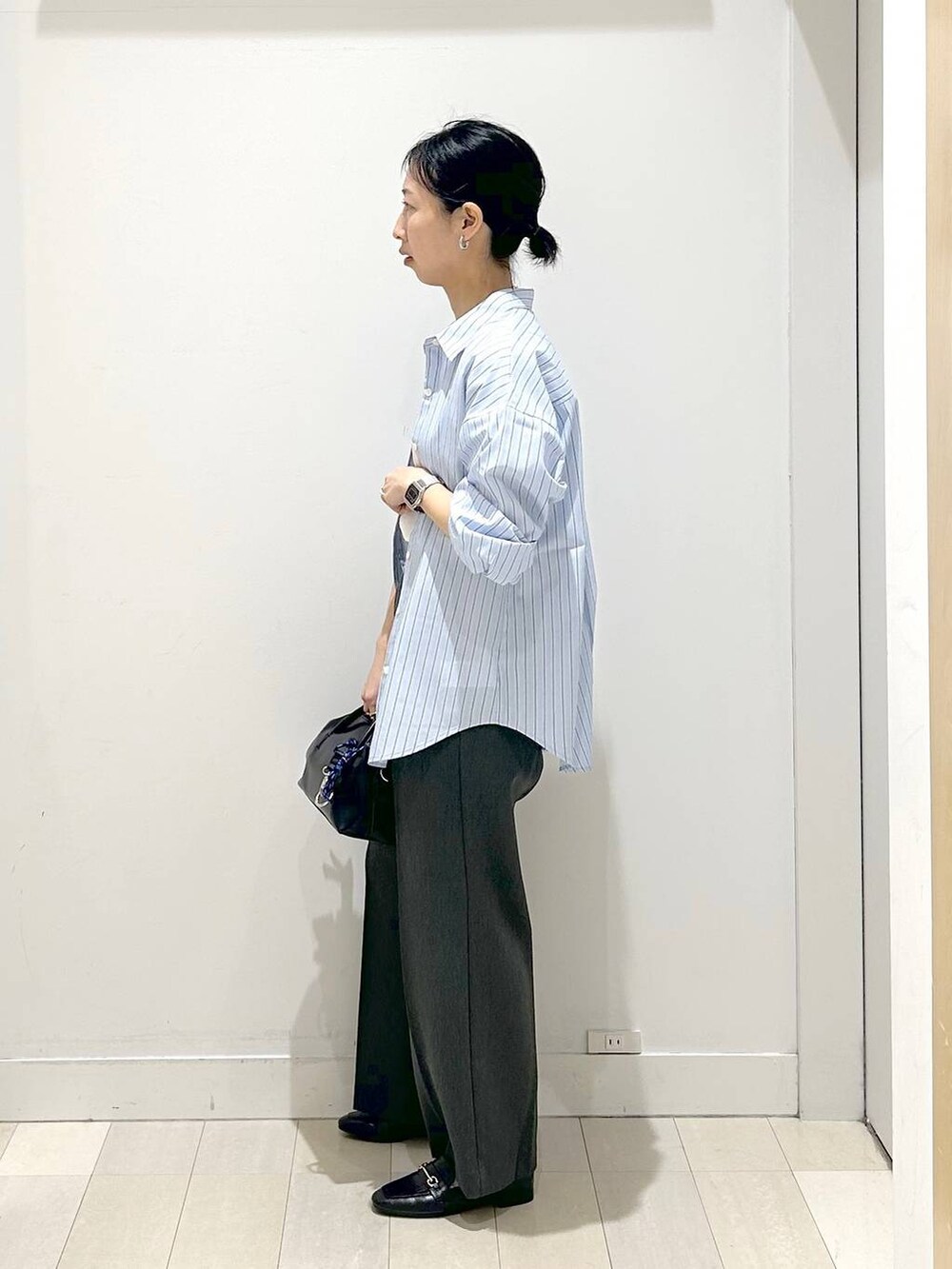 ブラック系のローファー、ブルー系のシャツ/ブラウス、グレー系のその他パンツを着用したレディースの春コーディネートの2枚目の写真