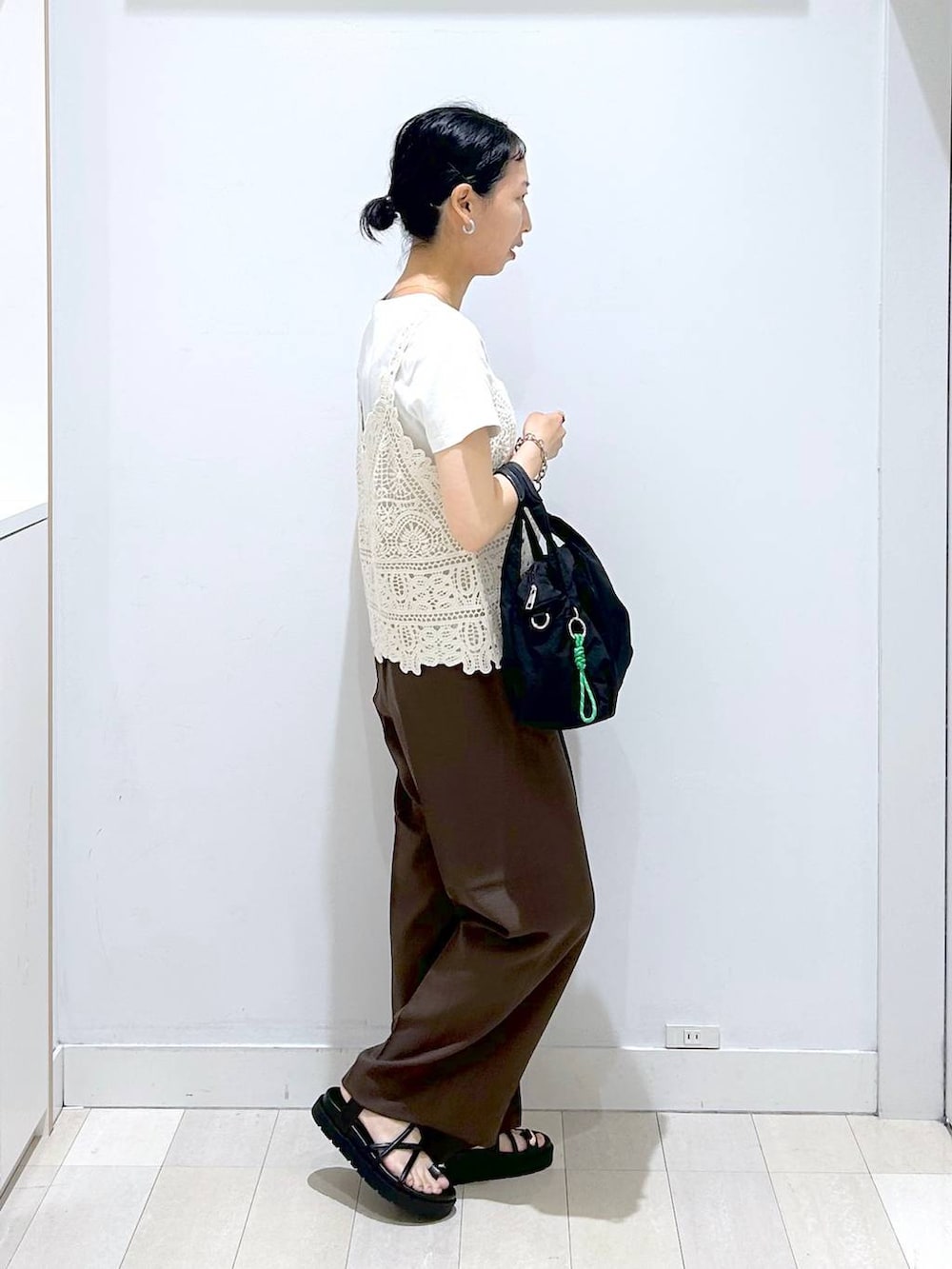 ブラック系のトートバッグ、ブラウン系のその他パンツ、ホワイト系のTシャツ/カットソーを着用したレディースの夏コーディネートの4枚目の写真