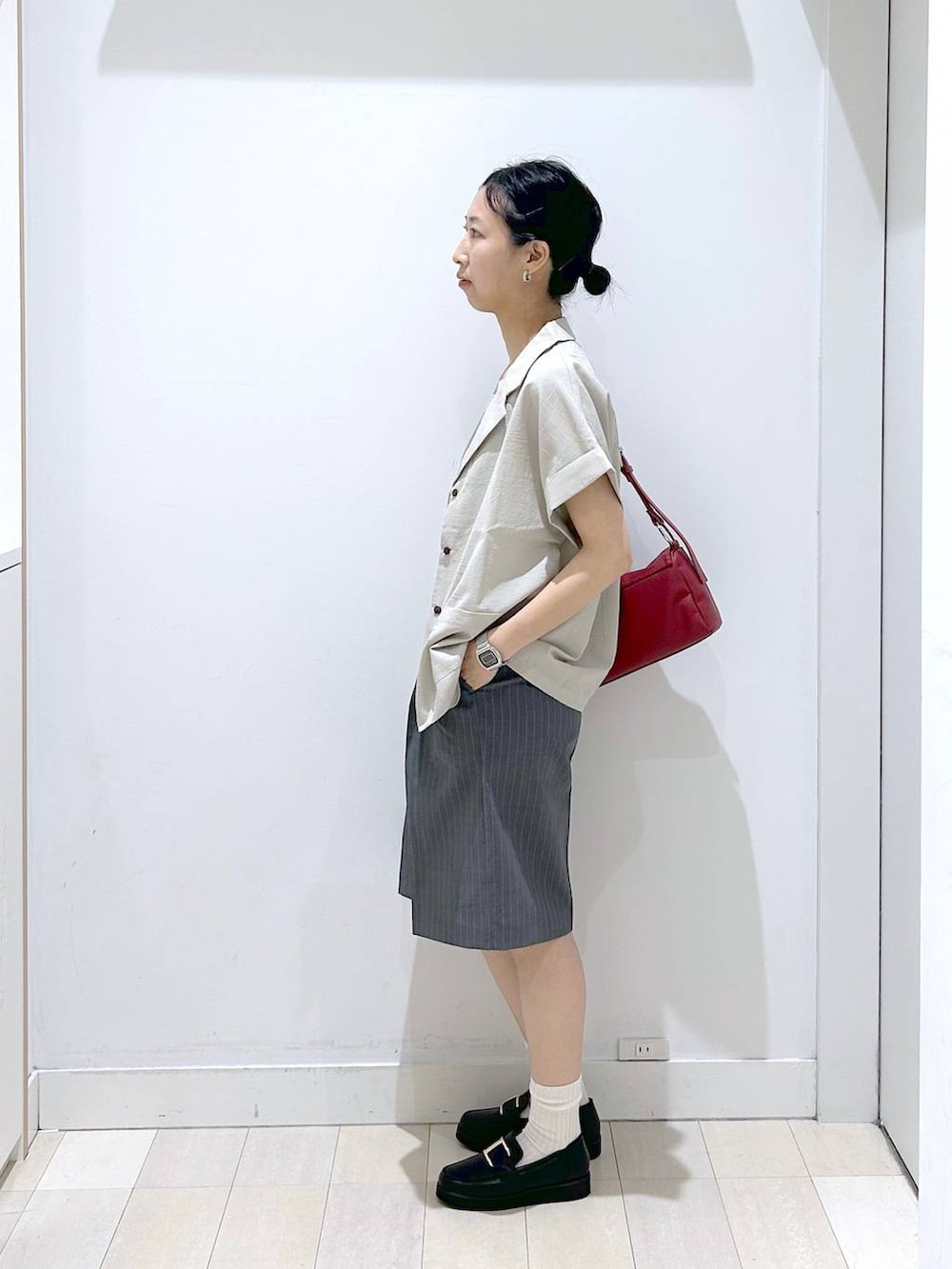 ブラック系のローファー、ベージュ系のシャツ/ブラウス、ホワイト系のタンクトップを着用したレディースの夏コーディネートの2枚目の写真