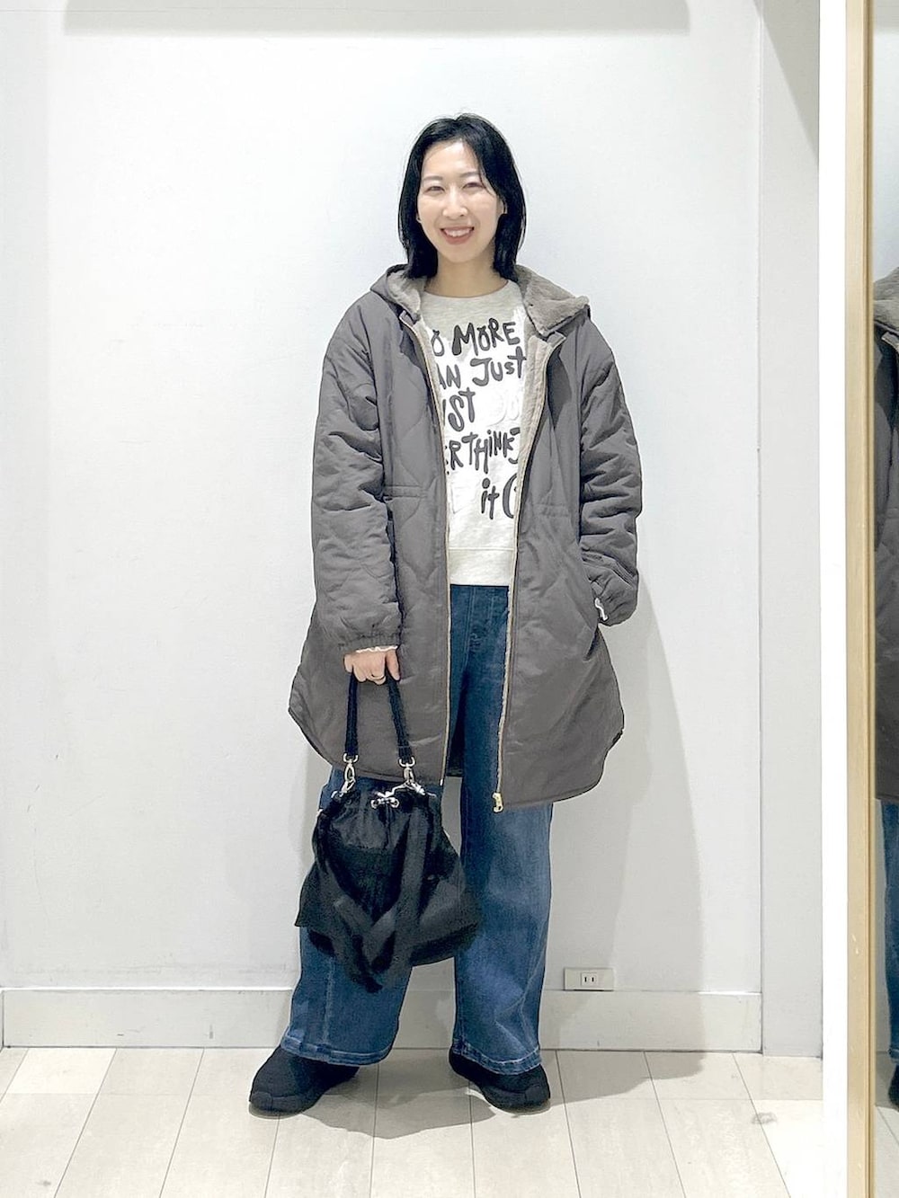 ブラック系のショルダーバッグ、ブラウン系のブルゾン、ホワイト系のTシャツ/カットソーを着用したレディースの冬コーディネートの5枚目の写真