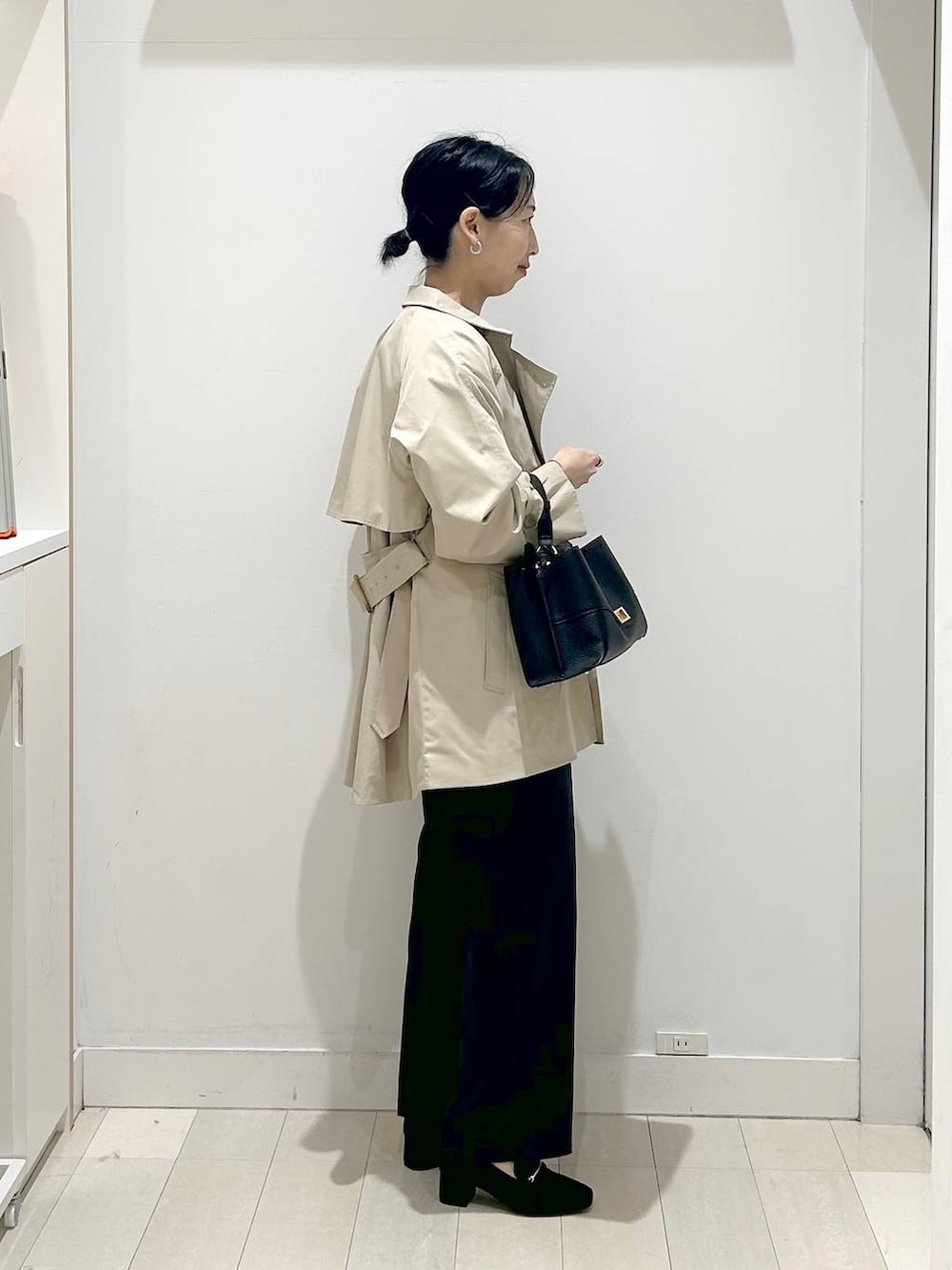 ブラック系のローファー、ブルー系のシャツ/ブラウス、ブラック系のショルダーバッグを着用したレディースの春コーディネートの2枚目の写真