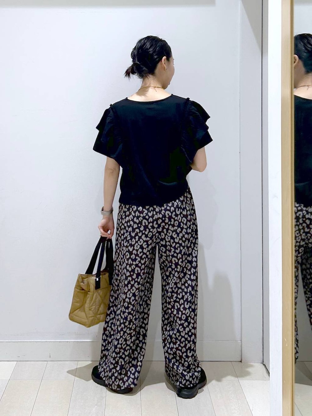 ブラウン系のトートバッグ、その他のその他パンツ、ブラック系のスニーカーを着用したレディースの春コーディネートの3枚目の写真