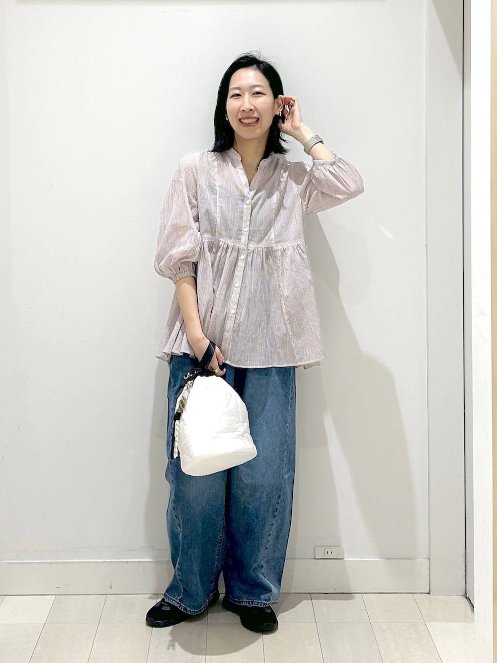 ホワイト系のハンドバッグ、ブルー系のデニムパンツ、レッド系のシャツ/ブラウスを着用したレディースの春コーディネートの5枚目の写真