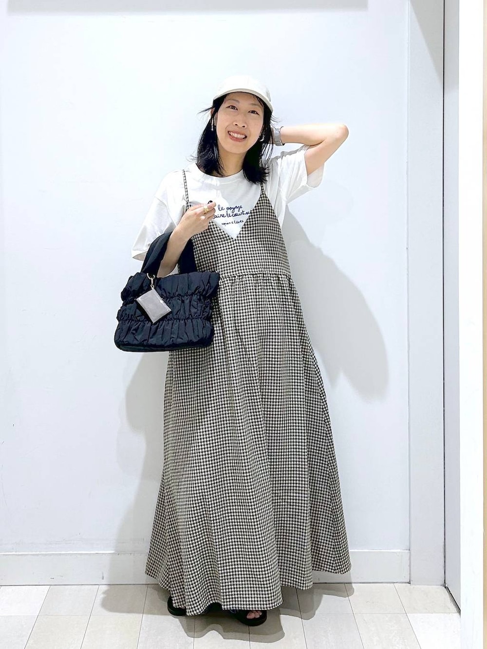 ブルー系のデニムパンツ、ブラック系のトートバッグ、ホワイト系のTシャツ/カットソーを着用したレディースの夏コーディネートの5枚目の写真