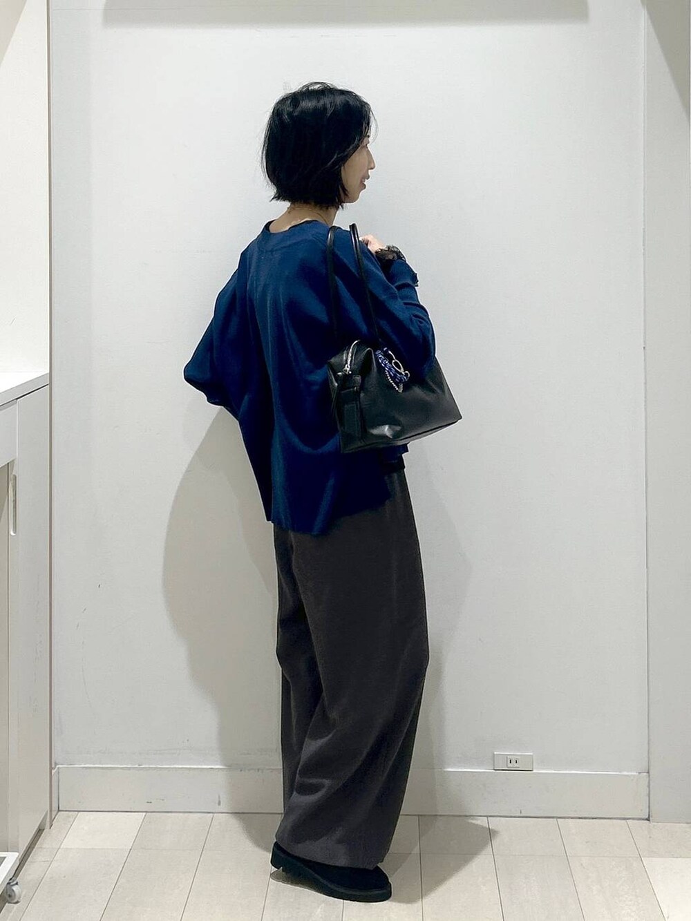 ブラック系のボストンバッグ、ブラック系のローファー、ブラック系のTシャツ/カットソーを着用したレディースの秋コーディネートの2枚目の写真