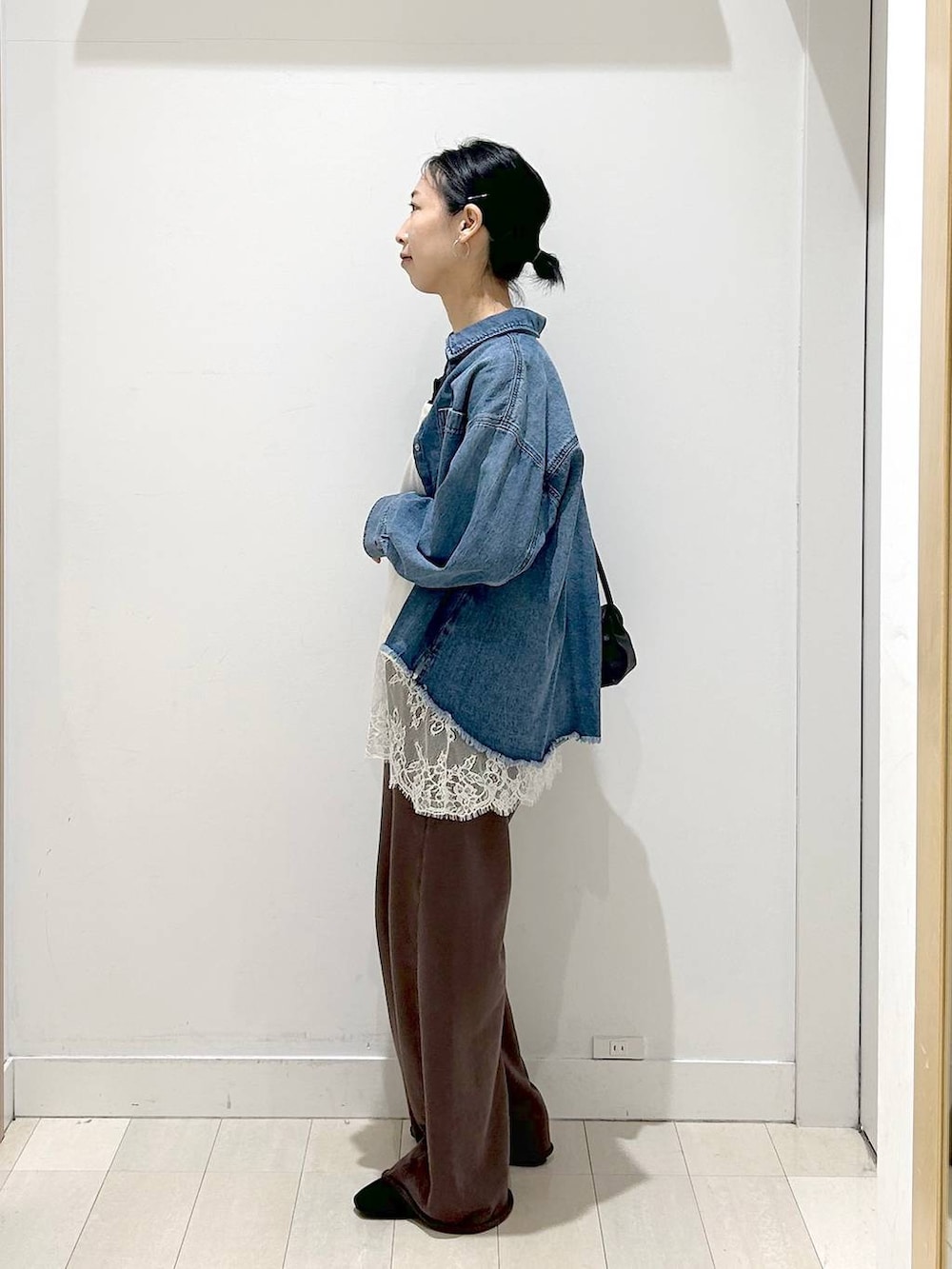 ブラック系のローファー、ブラック系のショルダーバッグ、ブルー系のシャツ/ブラウスを着用したレディースの春コーディネートの2枚目の写真