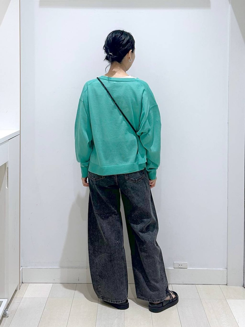 ブラック系のデニムパンツ、ホワイト系のTシャツ/カットソー、グリーン系のカーディガン/ボレロを着用したレディースの春コーディネートの3枚目の写真