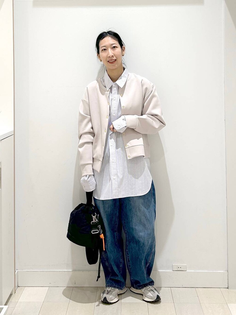 ブラック系のハンドバッグ、ブルー系のデニムパンツ、ピンク系のカーディガン/ボレロを着用したレディースの春コーディネートの5枚目の写真