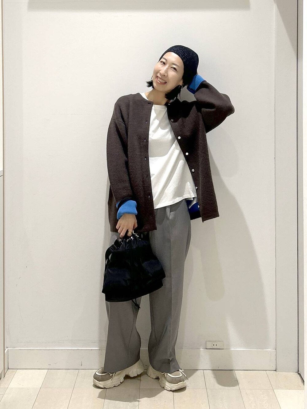 ブラック系のショルダーバッグ、グレー系のその他パンツ、ホワイト系のTシャツ/カットソーを着用したレディースの秋コーディネートの5枚目の写真