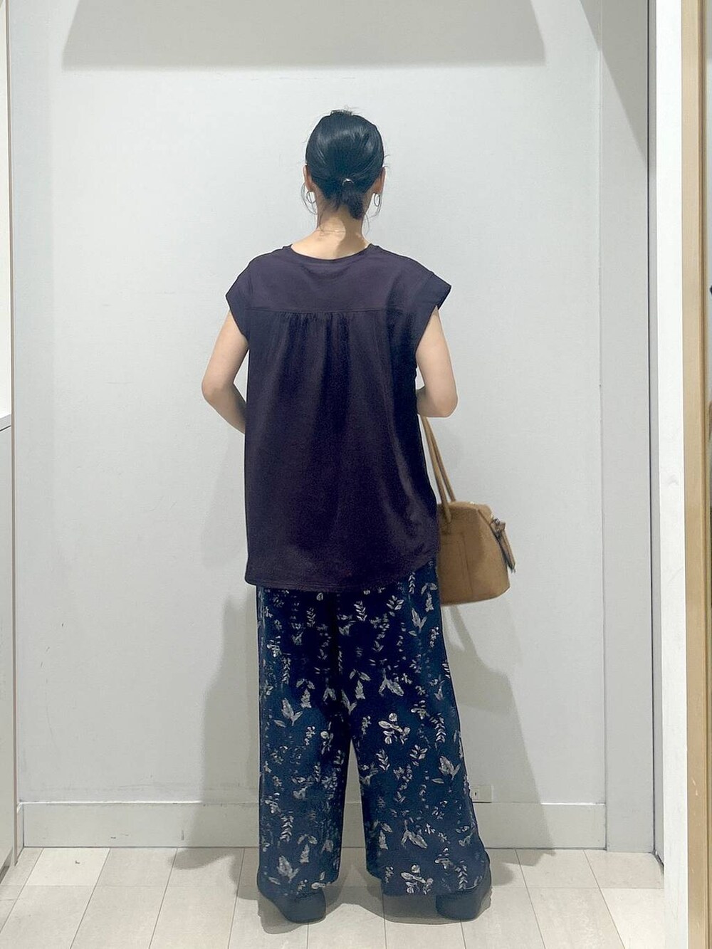 ブラック系のサンダル、ブラウン系のTシャツ/カットソー、ベージュ系のボストンバッグを着用したレディースの夏コーディネートの3枚目の写真