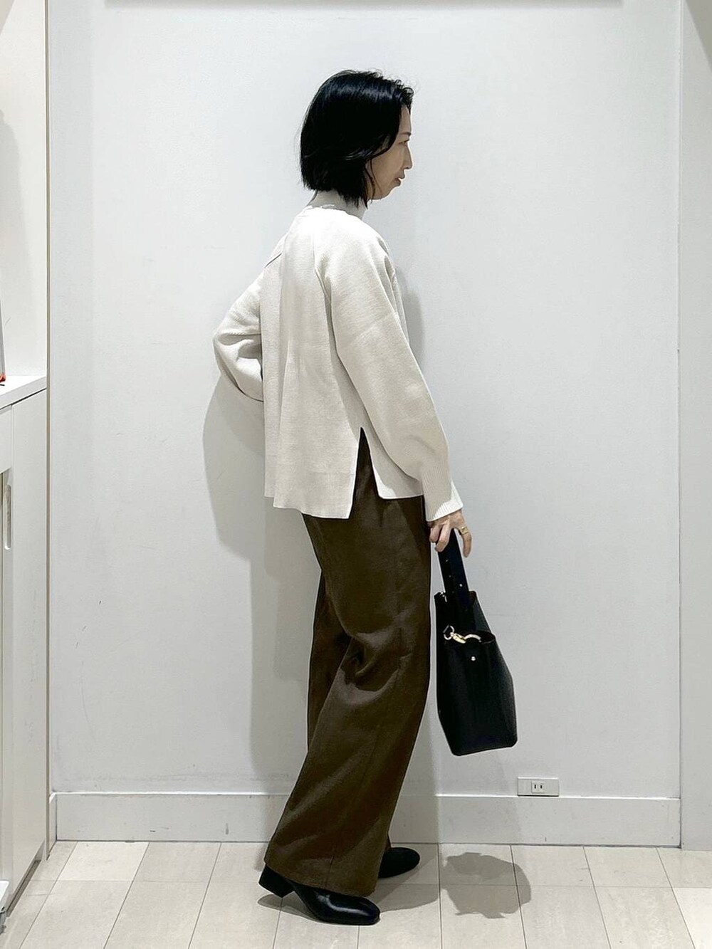 ブラック系のショルダーバッグ、ブラウン系のその他パンツ、ブラック系のブーツを着用したレディースの冬コーディネートの2枚目の写真