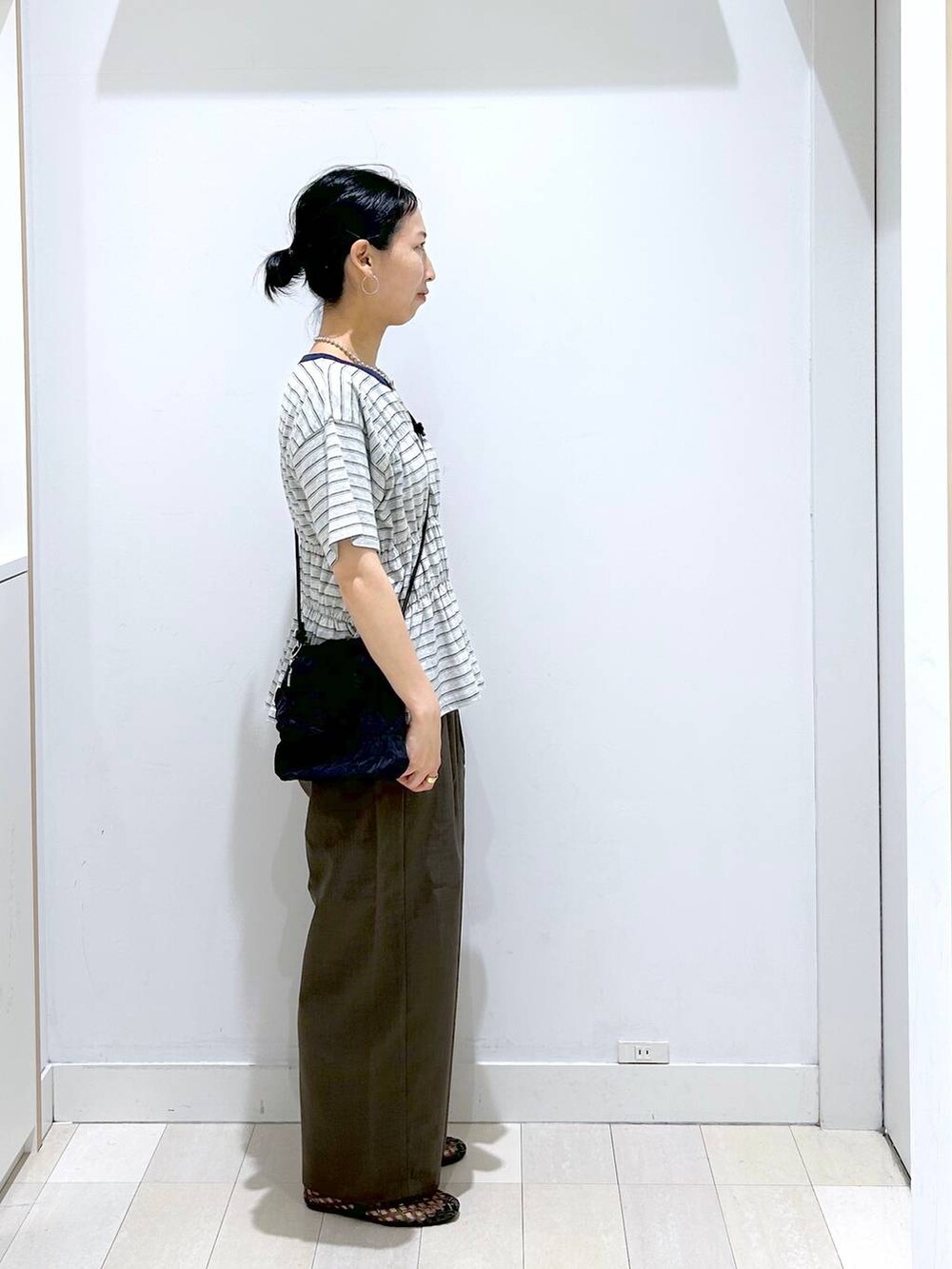 ブラウン系のその他パンツ、ブラック系のサンダル、グレー系のTシャツ/カットソーを着用したレディースの夏コーディネートの4枚目の写真