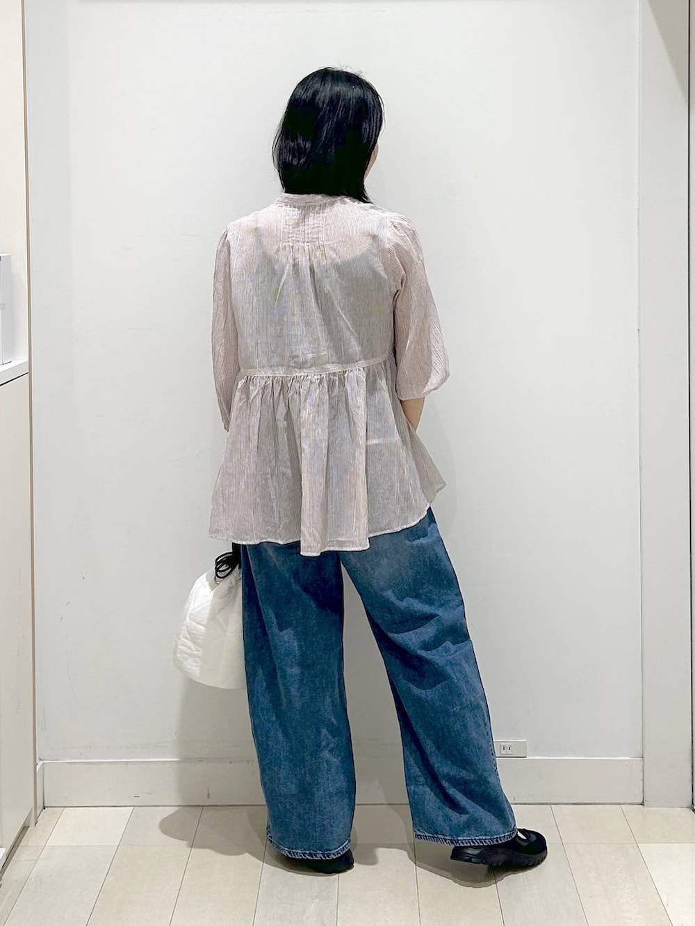 ホワイト系のハンドバッグ、ブルー系のデニムパンツ、レッド系のシャツ/ブラウスを着用したレディースの春コーディネートの3枚目の写真