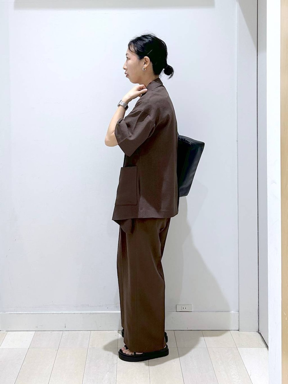 ブラウン系のテーラードジャケット、ブラウン系のその他パンツ、ブラック系のショルダーバッグを着用したレディースの夏コーディネートの2枚目の写真