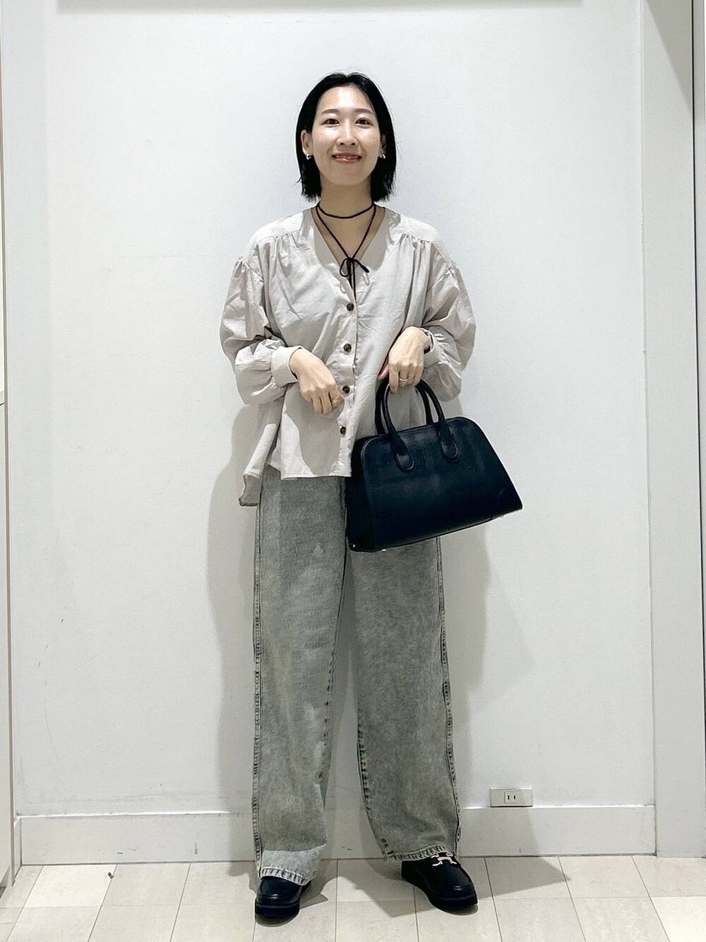 ブラック系のローファー、ブルー系のデニムパンツ、ベージュ系のシャツ/ブラウスを着用したレディースの秋コーディネートの5枚目の写真