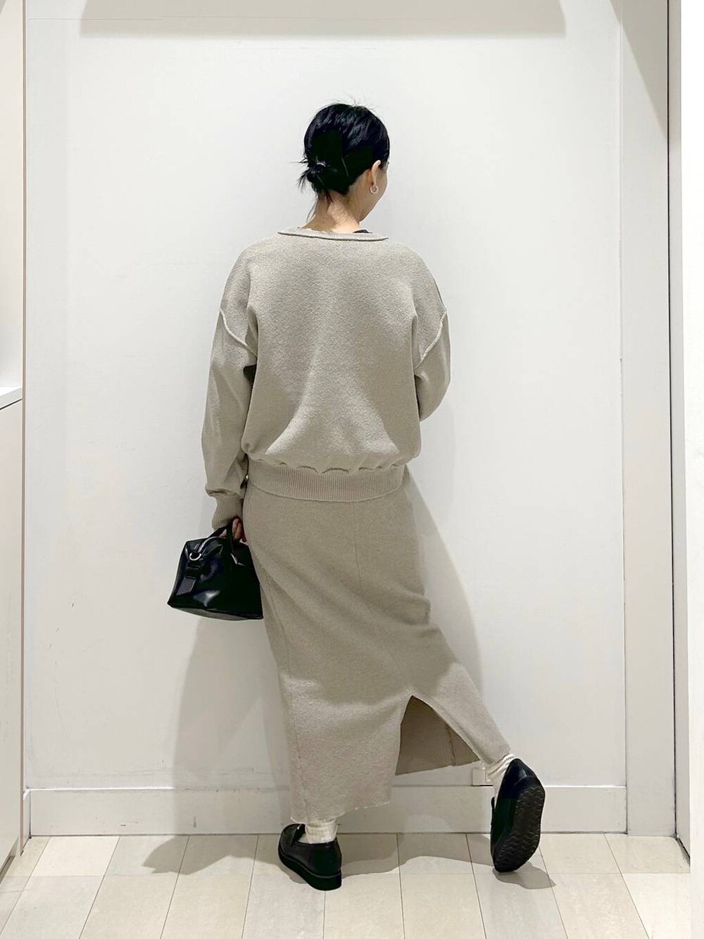 ブラック系のローファー、ベージュ系のワンピース、グレー系のTシャツ/カットソーを着用したレディースの春コーディネートの3枚目の写真