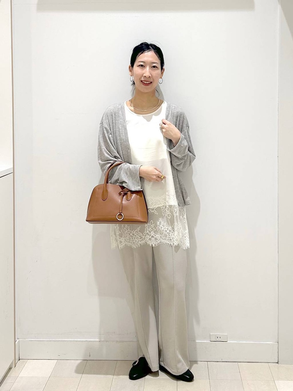 ブラック系のローファー、ブラウン系のショルダーバッグ、ベージュ系のその他パンツを着用したレディースの春コーディネートの5枚目の写真