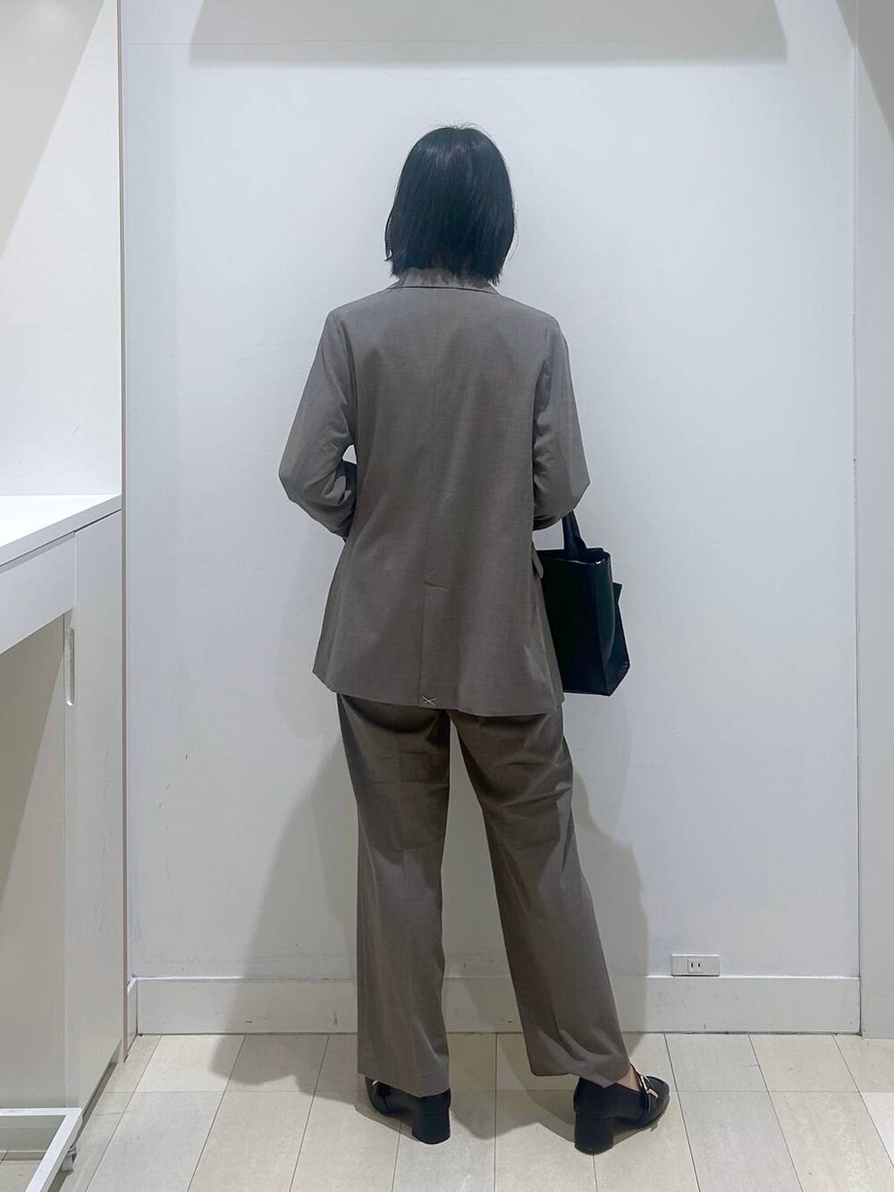 ブラック系のローファー、ブラウン系のスラックス、ホワイト系のシャツ/ブラウスを着用したレディースの冬コーディネートの3枚目の写真