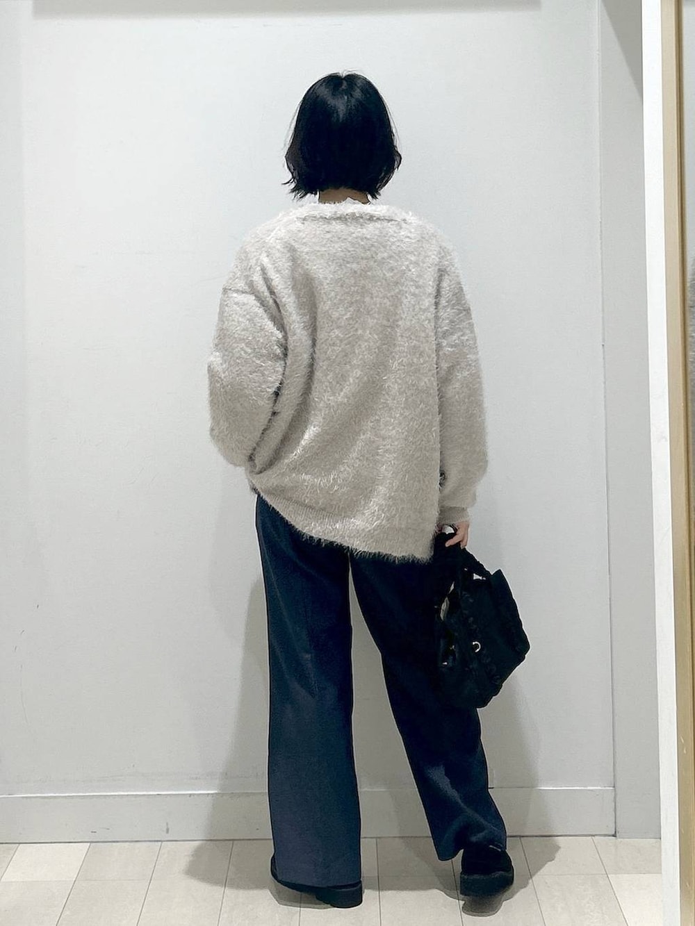 ブラック系のボストンバッグ、ブラック系のローファー、ブルー系のその他パンツを着用したレディースの秋コーディネートの3枚目の写真