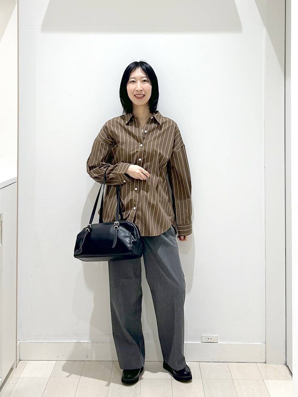 ブラック系のローファー、ブラウン系のシャツ/ブラウス、グレー系のスラックスを着用したレディースの春コーディネートの5枚目の写真