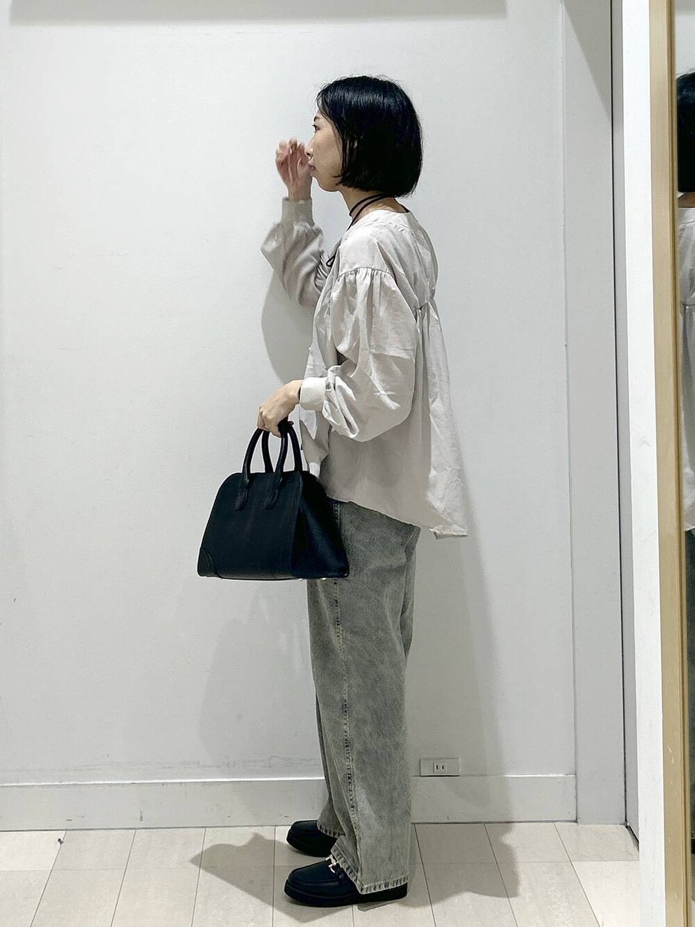 ブラック系のローファー、ブルー系のデニムパンツ、ベージュ系のシャツ/ブラウスを着用したレディースの秋コーディネートの4枚目の写真