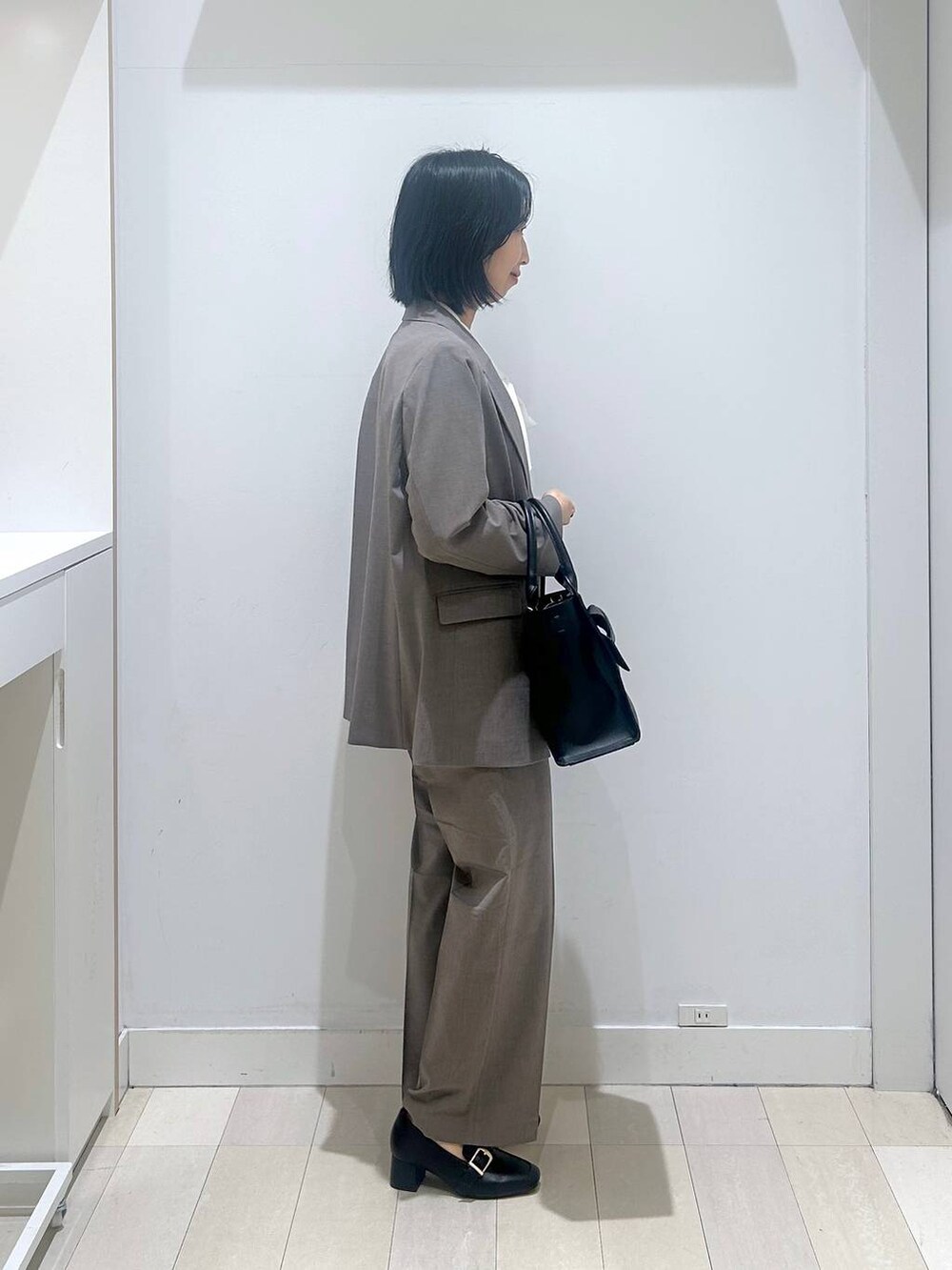 ブラック系のローファー、ブラウン系のスラックス、ホワイト系のシャツ/ブラウスを着用したレディースの冬コーディネートの4枚目の写真