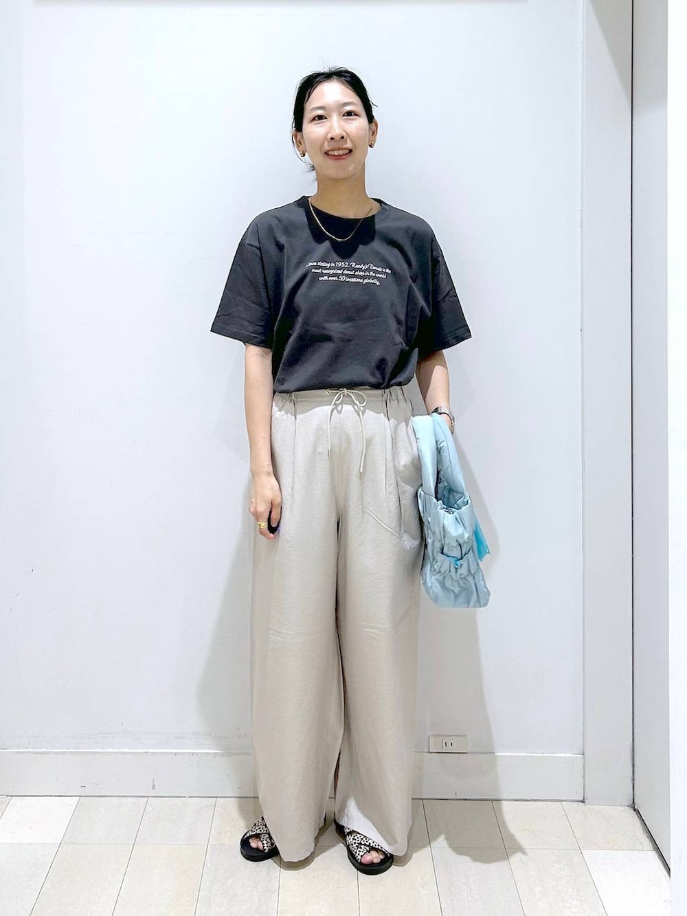 ブルー系のトートバッグ、ベージュ系のその他パンツ、ブラック系のサンダルを着用したレディースの夏コーディネートの5枚目の写真
