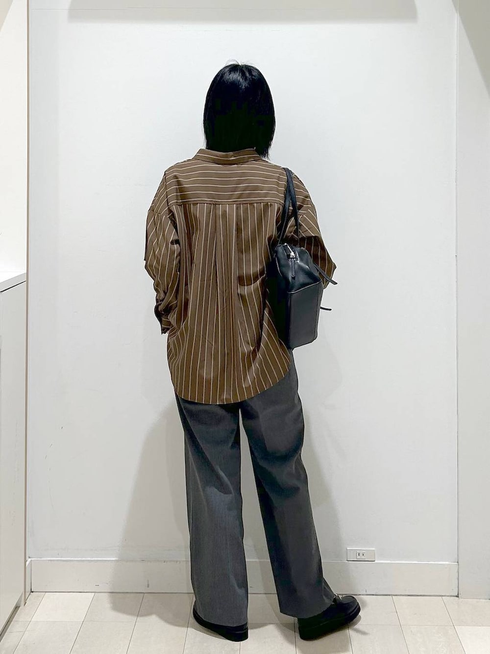 ブラック系のローファー、ブラウン系のシャツ/ブラウス、グレー系のスラックスを着用したレディースの春コーディネートの3枚目の写真