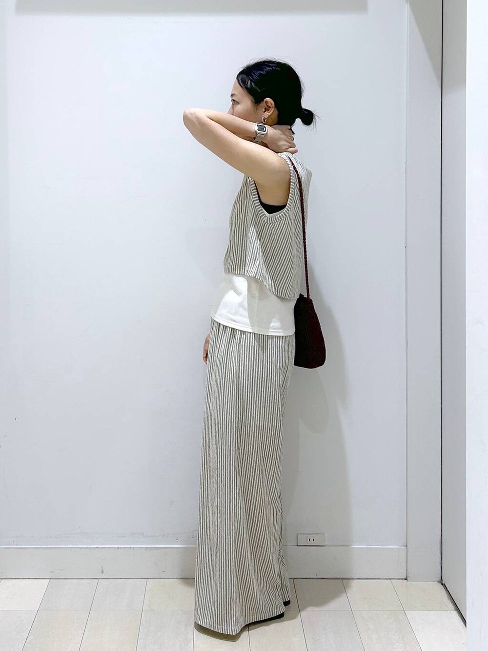 ブラウン系のクラッチバッグ、ホワイト系のその他パンツ、ホワイト系のTシャツ/カットソーを着用したレディースの夏コーディネートの4枚目の写真
