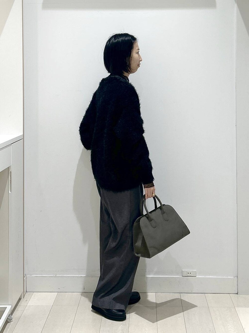 ブラック系のローファー、グレー系のその他パンツ、グリーン系のショルダーバッグを着用したレディースの秋コーディネートの2枚目の写真