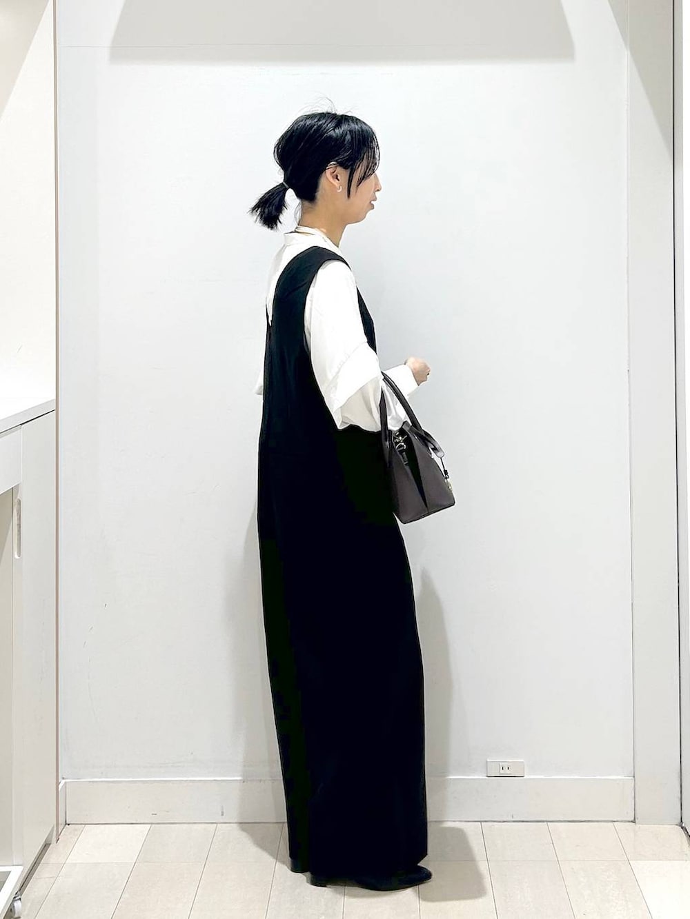 ブラック系のショルダーバッグ、ブラック系のセットアップ、ブラック系のローファーを着用したレディースの冬コーディネートの4枚目の写真