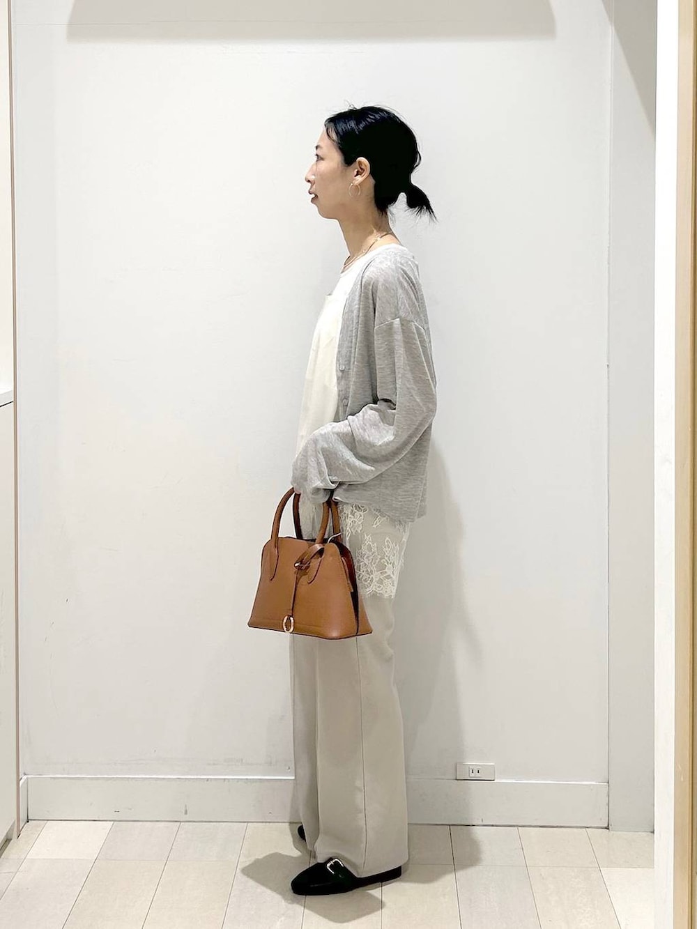 ブラック系のローファー、ブラウン系のショルダーバッグ、ベージュ系のその他パンツを着用したレディースの春コーディネートの2枚目の写真