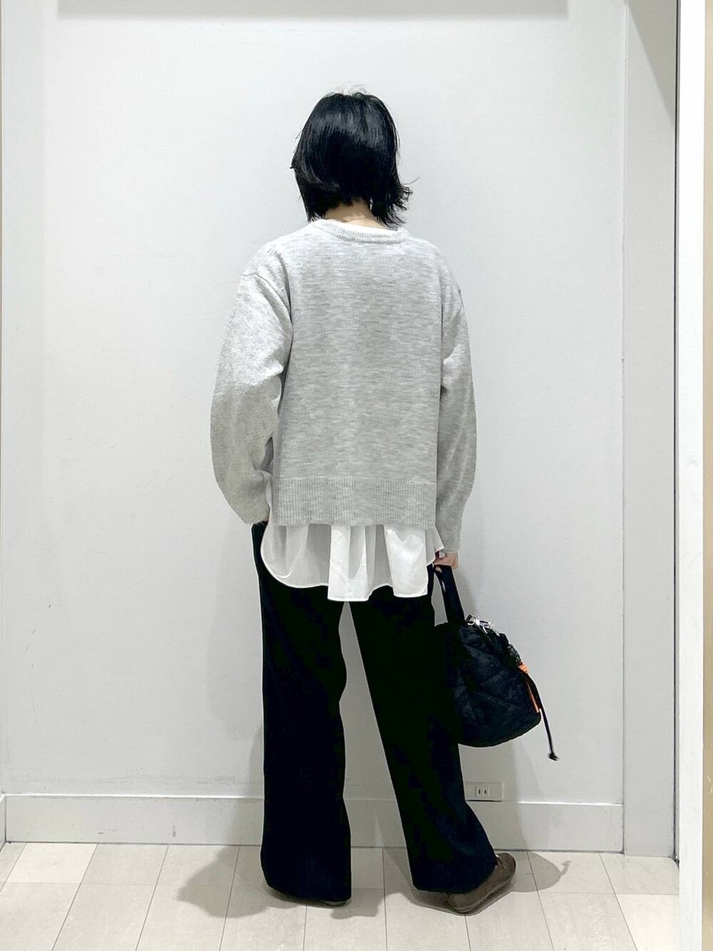 ブラック系のハンドバッグ、シルバー系のニット/セーター、ブラック系のその他パンツを着用したレディースの冬コーディネートの3枚目の写真