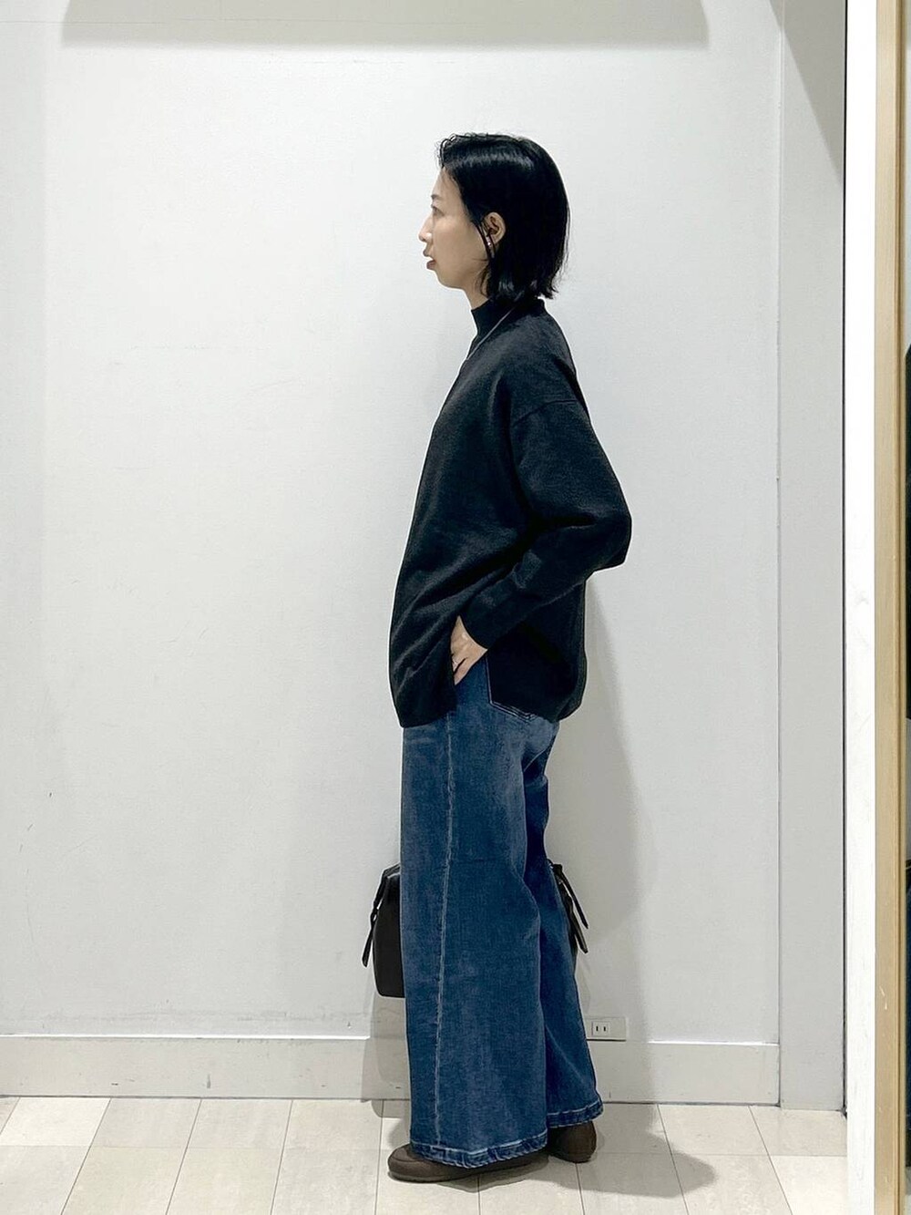 ブラウン系のボストンバッグ、グレー系のニット/セーター、ブラウン系のローファーを着用したレディースの冬コーディネートの4枚目の写真