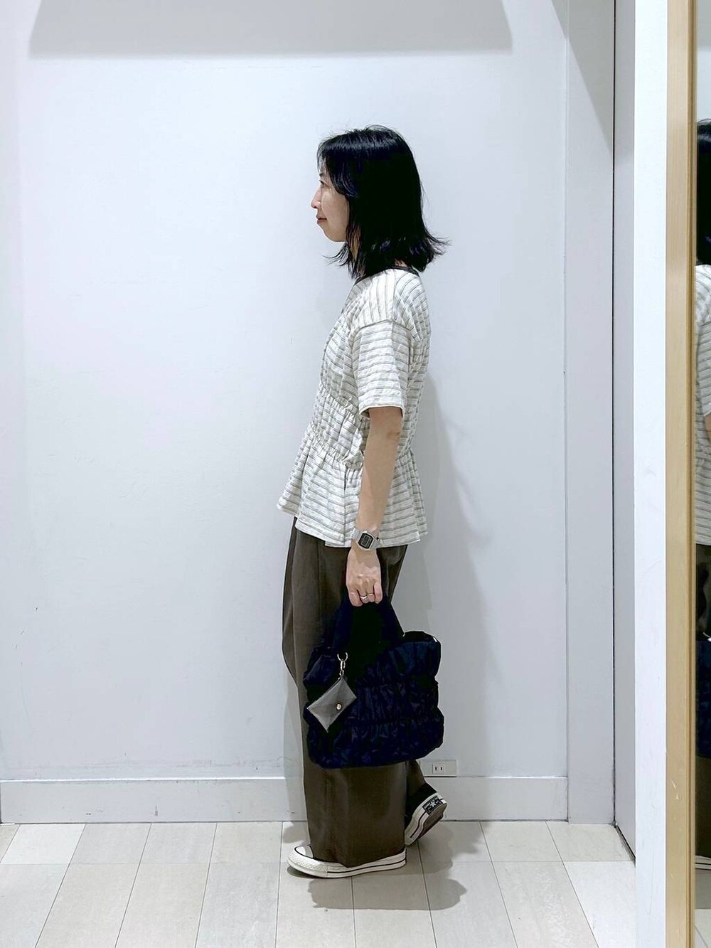 ブラック系のトートバッグ、ブラウン系のその他パンツ、ホワイト系のTシャツ/カットソーを着用したレディースの夏コーディネートの2枚目の写真