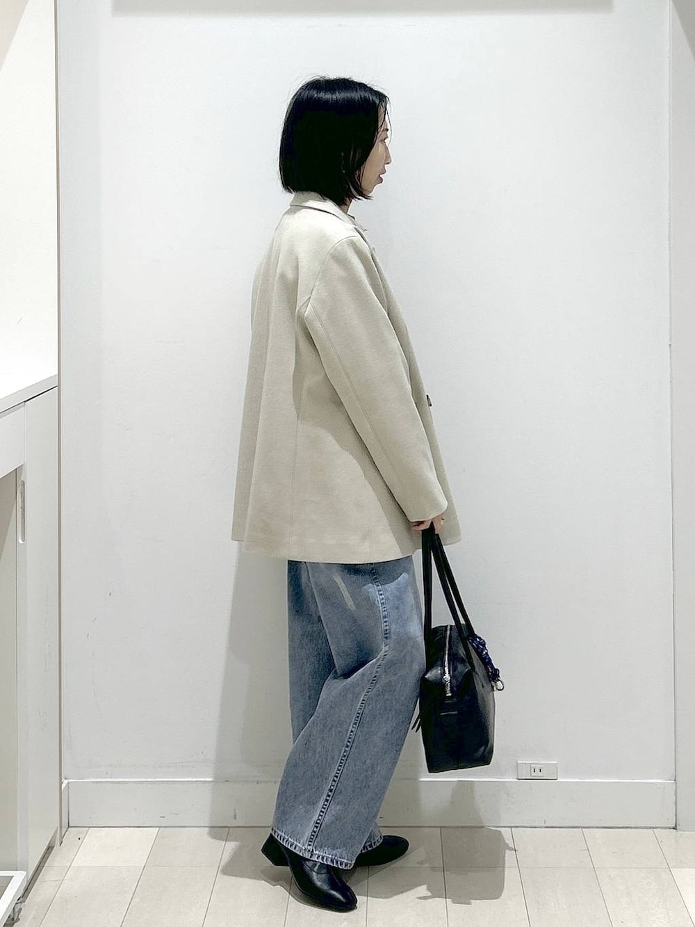 ブラック系のボストンバッグ、ブルー系のデニムパンツ、その他のシャツ/ブラウスを着用したレディースの冬コーディネートの2枚目の写真