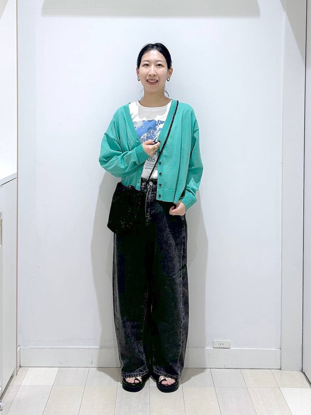 ブラック系のデニムパンツ、ホワイト系のTシャツ/カットソー、グリーン系のカーディガン/ボレロを着用したレディースの春コーディネートの5枚目の写真