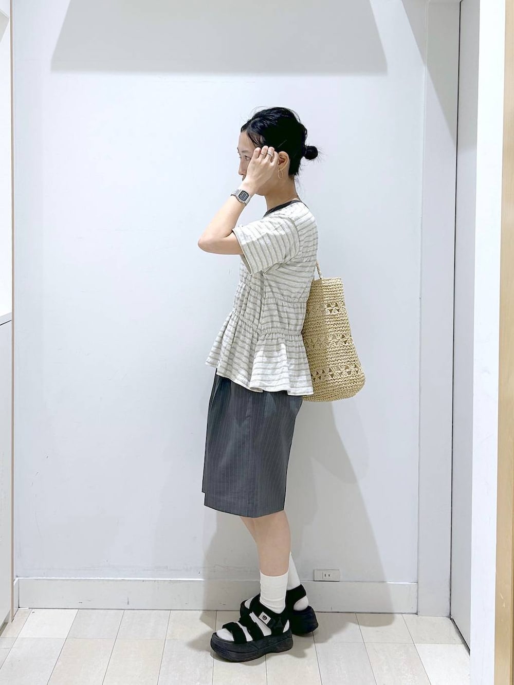ベージュ系のトートバッグ、グレー系のその他パンツ、ホワイト系のTシャツ/カットソーを着用したレディースの夏コーディネートの2枚目の写真