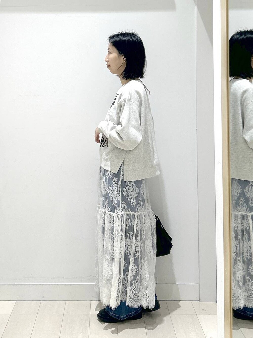 ブラック系のショルダーバッグ、ブラウン系のワンピース、ブラック系のブーツを着用したレディースの冬コーディネートの3枚目の写真