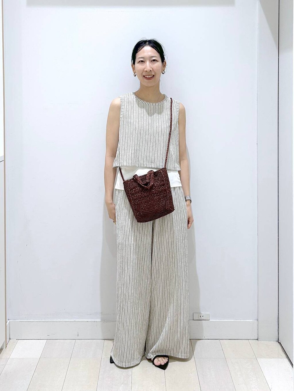 ブラウン系のクラッチバッグ、ホワイト系のその他パンツ、ホワイト系のTシャツ/カットソーを着用したレディースの夏コーディネートの5枚目の写真