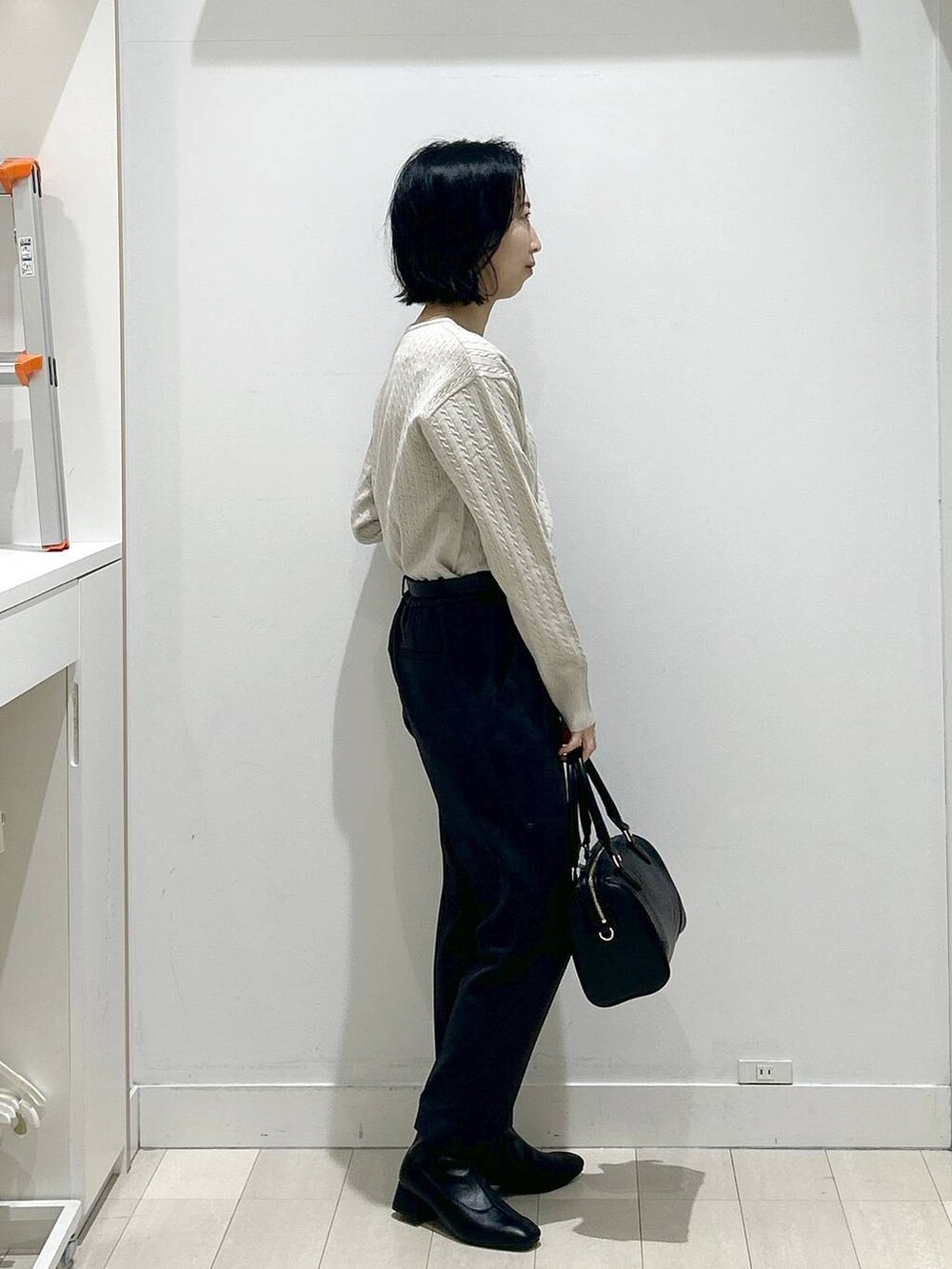 グレー系のその他パンツ、ブラック系のボストンバッグ、ブラック系のブーツを着用したレディースの冬コーディネートの2枚目の写真