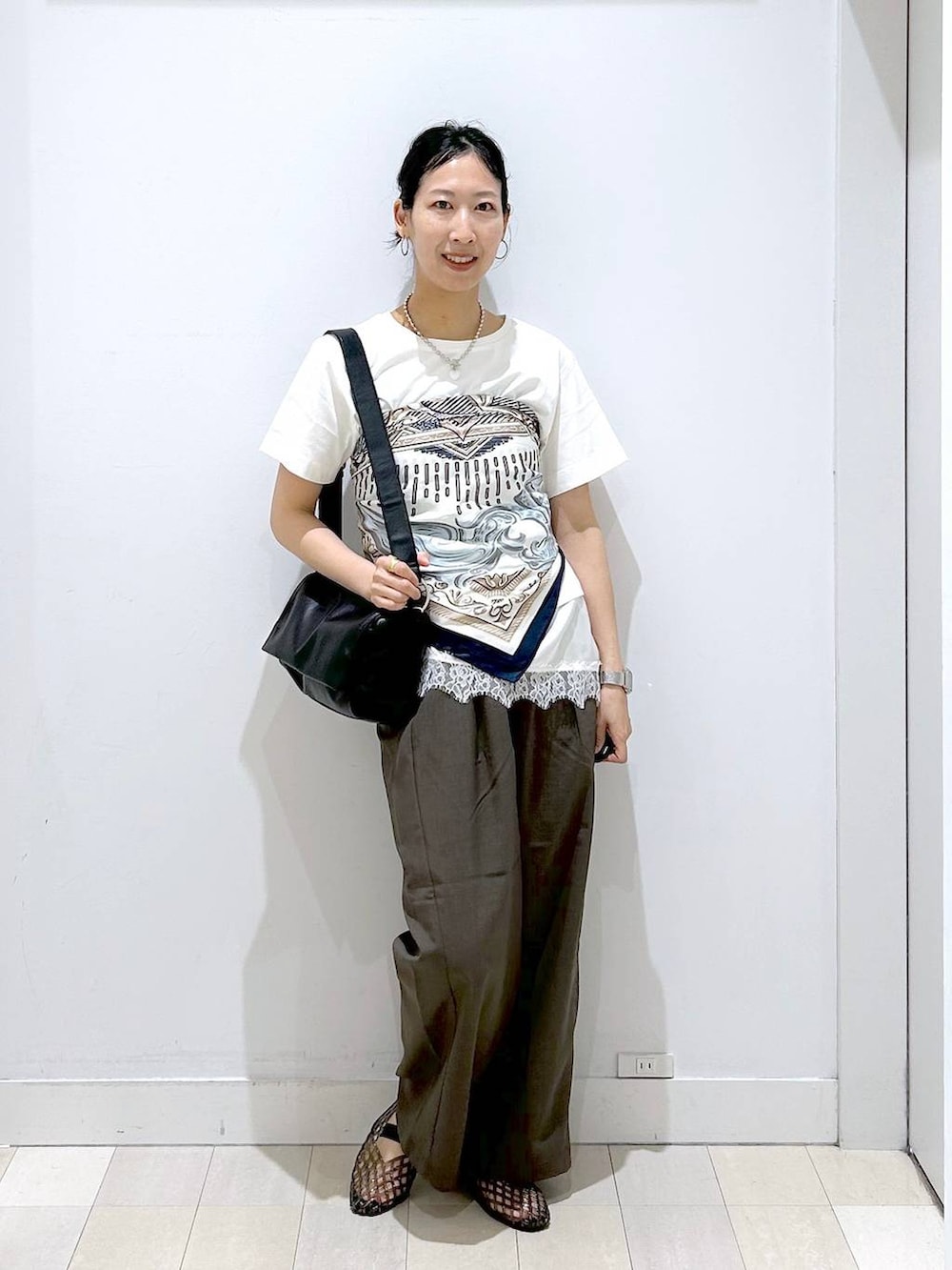 ブラウン系のその他パンツ、ブラック系のショルダーバッグ、ベージュ系のTシャツ/カットソーを着用したレディースの夏コーディネートの5枚目の写真