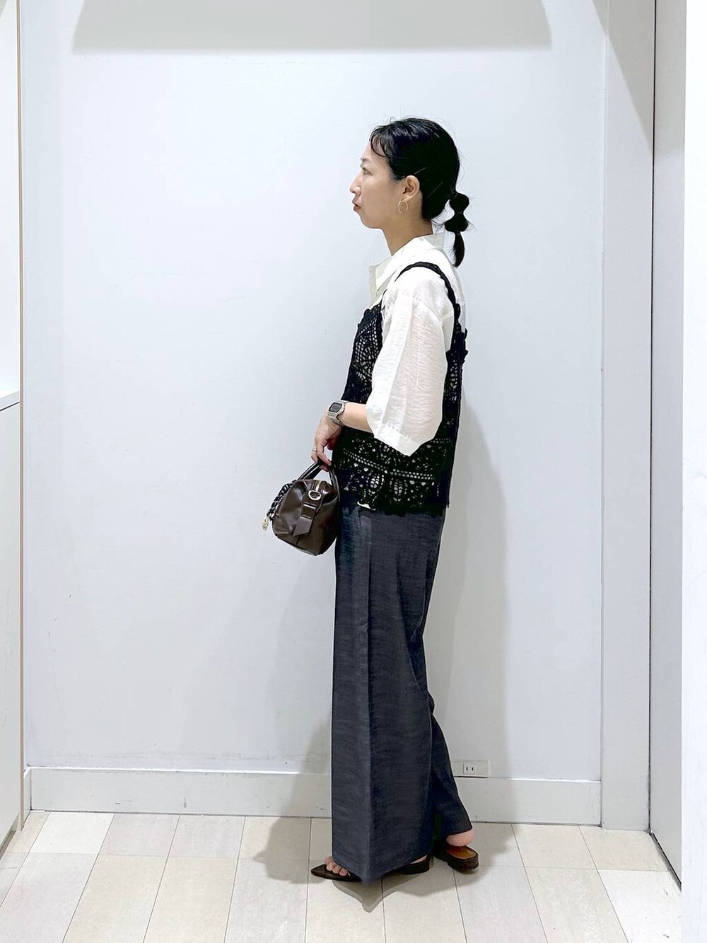 ブラック系のその他パンツ、ホワイト系のシャツ/ブラウス、ブラウン系のボストンバッグを着用したレディースの夏コーディネートの2枚目の写真