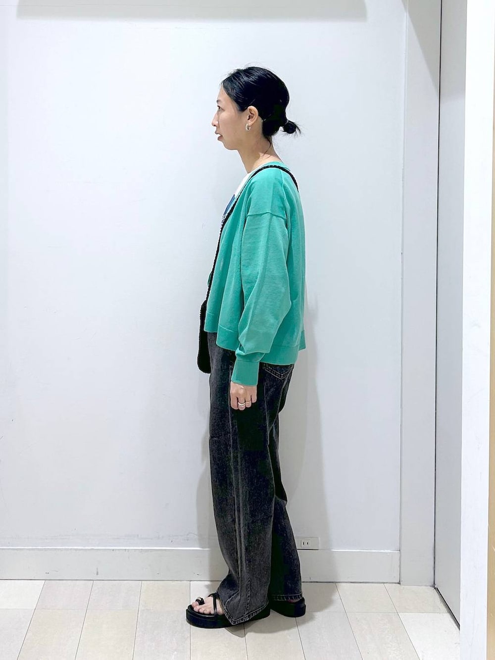 ブラック系のデニムパンツ、ホワイト系のTシャツ/カットソー、グリーン系のカーディガン/ボレロを着用したレディースの春コーディネートの2枚目の写真