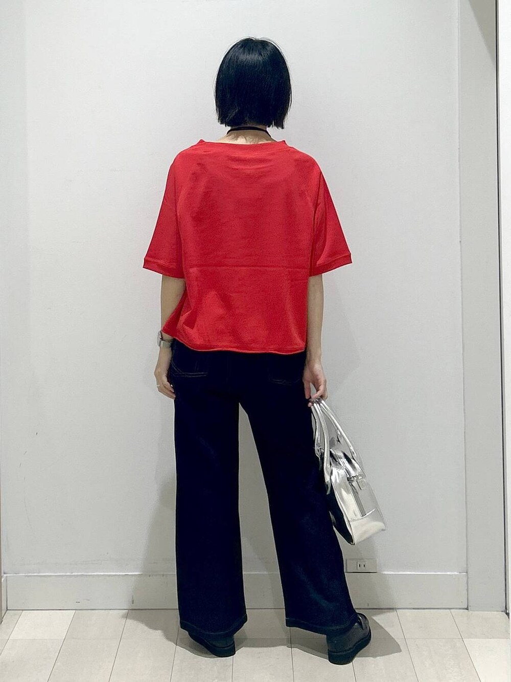 ブラック系のローファー、グレー系のボストンバッグ、ブルー系のデニムパンツを着用したレディースの秋コーディネートの3枚目の写真