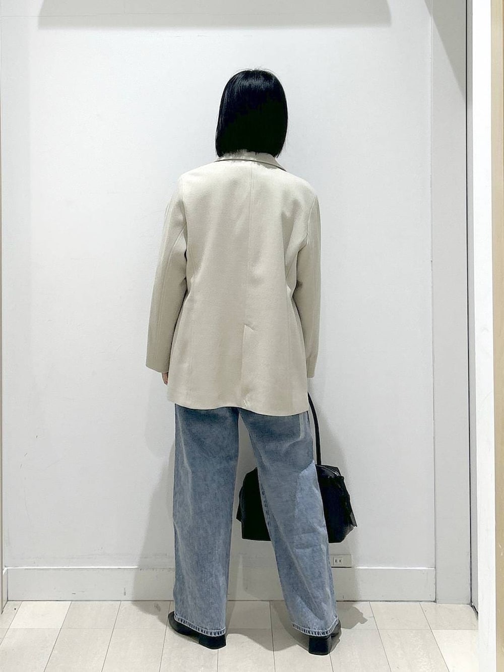 ブラック系のボストンバッグ、ブルー系のデニムパンツ、その他のシャツ/ブラウスを着用したレディースの冬コーディネートの3枚目の写真