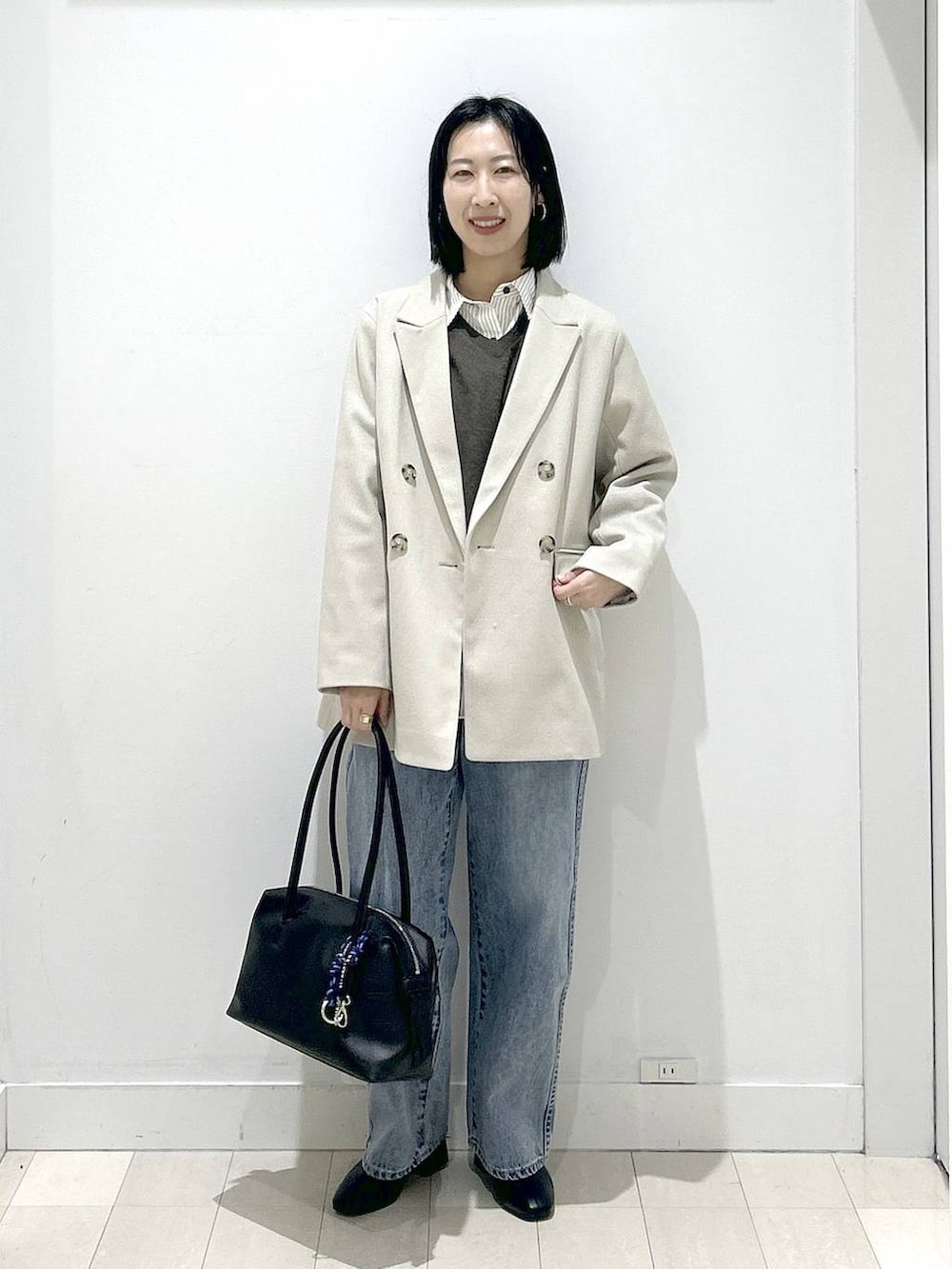 ブラック系のボストンバッグ、ブルー系のデニムパンツ、その他のシャツ/ブラウスを着用したレディースの冬コーディネートの5枚目の写真