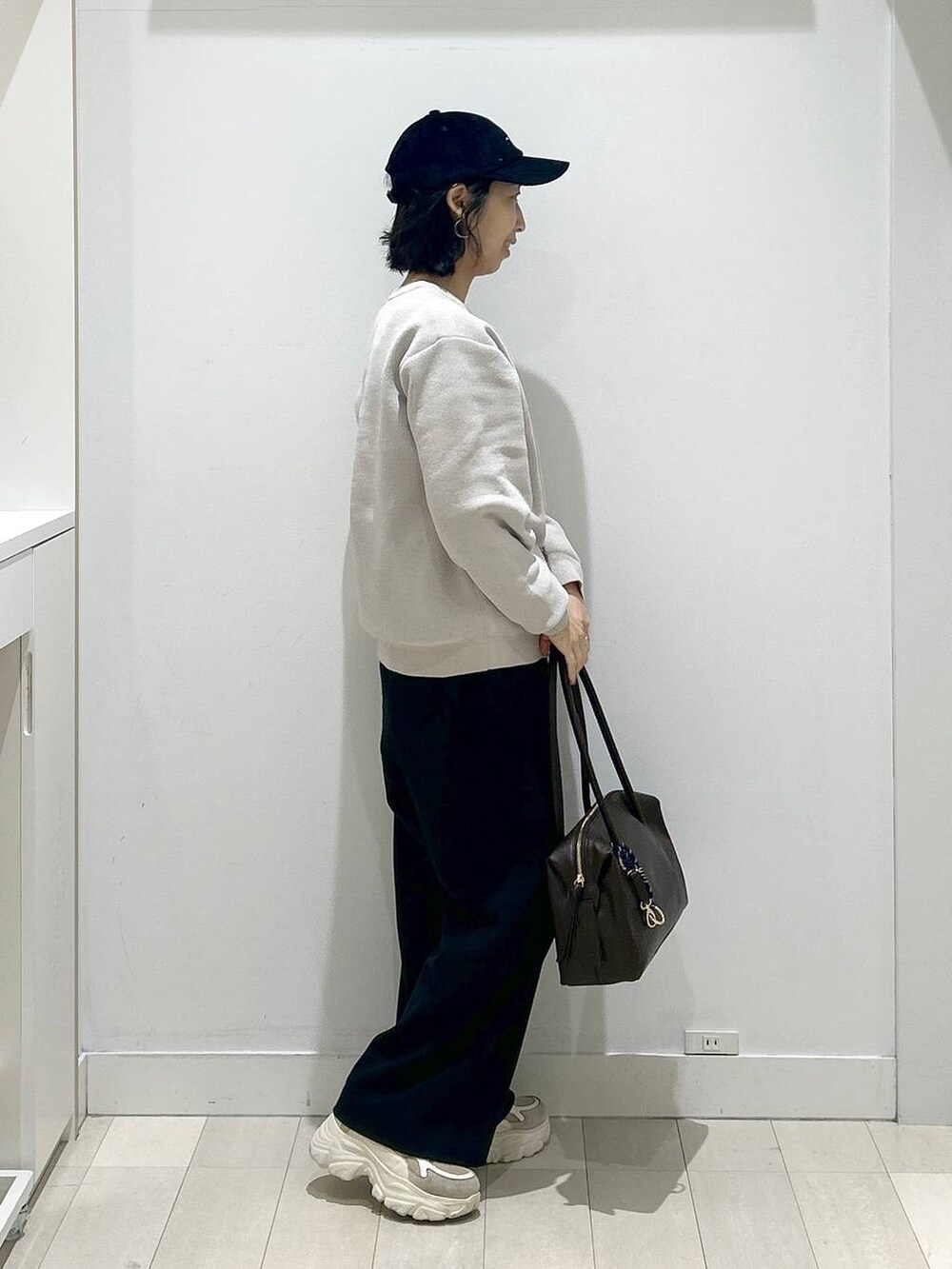 ブラウン系のボストンバッグ、ブラック系のその他パンツ、ベージュ系のTシャツ/カットソーを着用したレディースの冬コーディネートの2枚目の写真