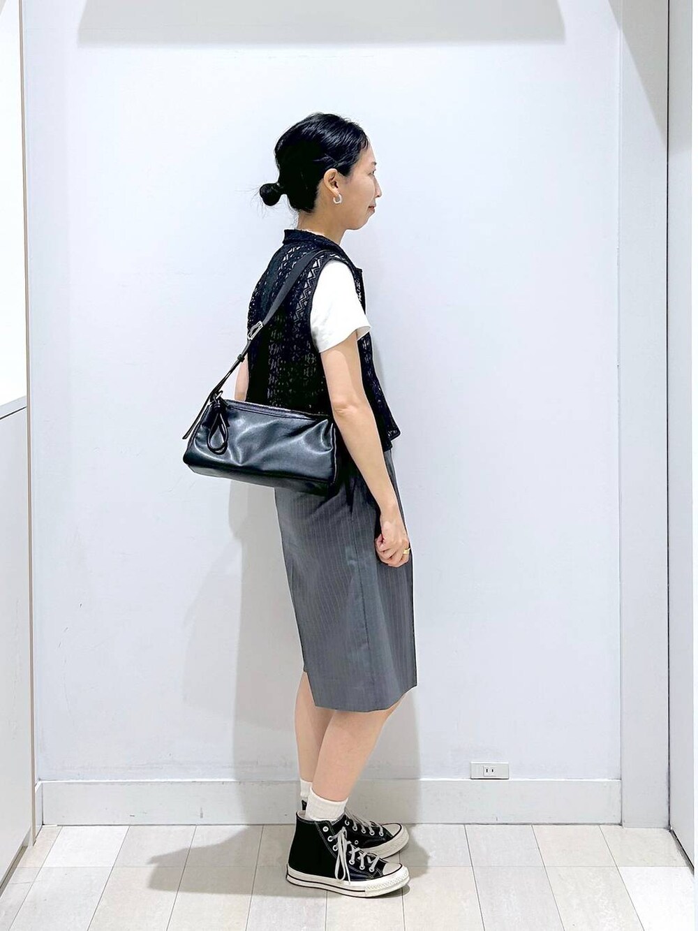 ブラック系のショルダーバッグ、ホワイト系のTシャツ/カットソー、ブラック系のベストを着用したレディースの夏コーディネートの4枚目の写真
